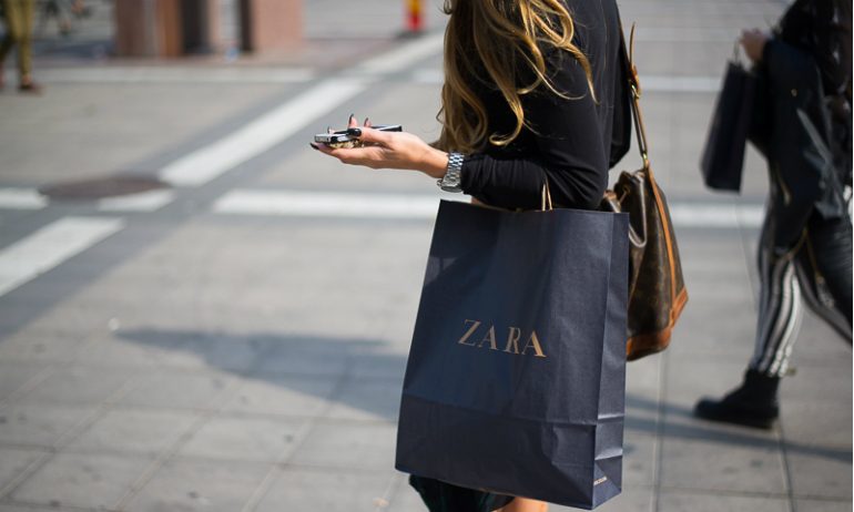 Mujer paseando con una bolsa de Zara