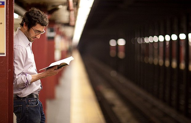 Hombre leyendo mientras espera el metro