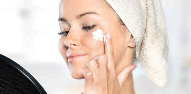 Mujer aplicándose crema facial